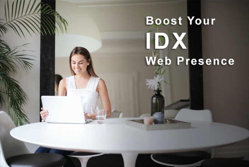 Woman sitting and using a laptop for a blog post, showcasing visually appealing and functional elements for real estate websites.